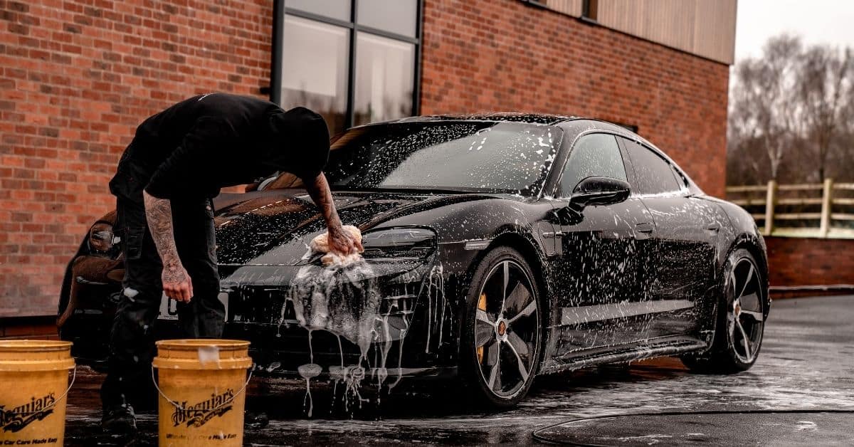 Man wast auto met autoshampoo